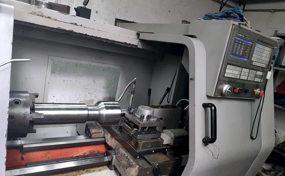 Torno CNC maquinando una flecha de acero